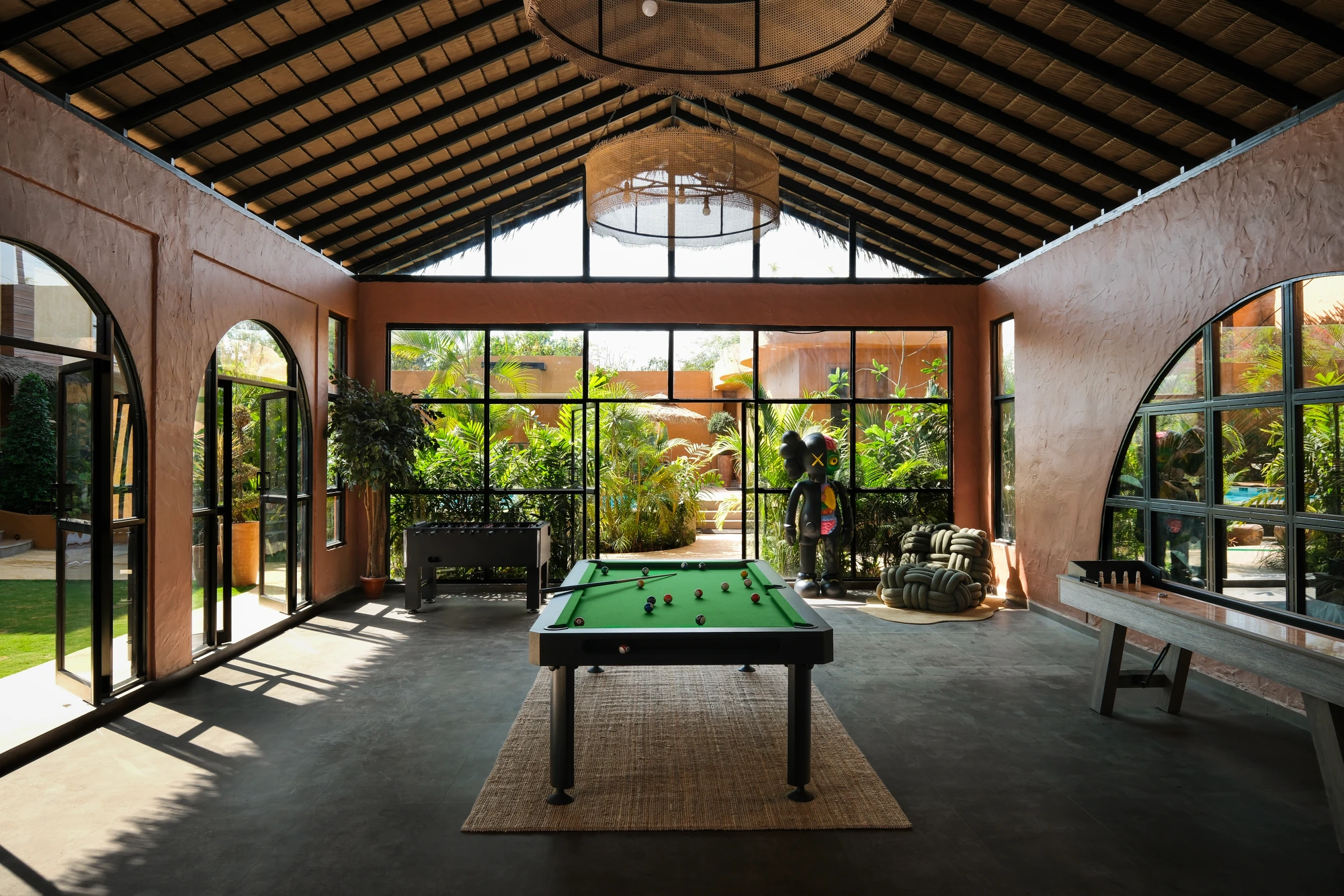 The games lounge with a pool table and arched windows inside a Dune Villa